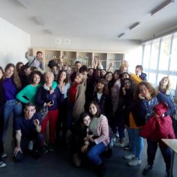 Stowarzyszenie Kultura Ponad Wszystko - Duża grupa uczniów i nauczycieli pozuje do zdjęcia w klasie z białymi ścianami i oknami z żaluzjami.