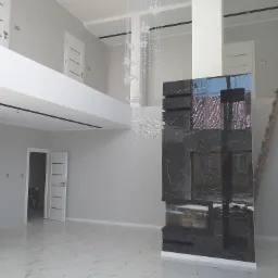 Nowoczesne wnętrze domu z marmurową podłogą, dwupoziomową przestrzenią, kryształowym żyrandolem i obudowanym kominkiem z czarnego marmuru, drabina oparta o ścianę, widoczne drzwi.