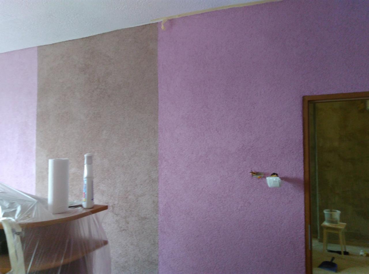 Fragment ściany z dwoma różnymi kolorami i fakturami, zabezpieczone listwy przy suficie, widoczne akcesoria malarskie na półce i przygotowane gniazdko elektryczne.