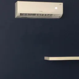 Biała jednostka klimatyzacyjna marki Rotenso zamontowana na ciemnoniebieskiej ścianie, wyświetlająca temperaturę 23 stopnie, z fragmentem białej półki w dolnej części kadru.