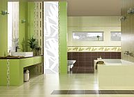 Jasnozielona łazienka z nowoczesną armaturą, białymi sanitariatami i dekoracyjnym panelem ściennym z motywem liści, widoczne lustro, umywalka i wanna.