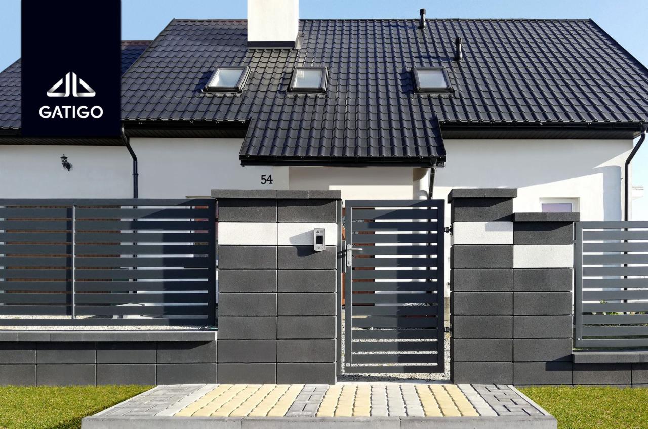 Nowoczesne ogrodzenie panelowe z bramą wjazdową, wykonane z szarych prefabrykatów betonowych i poziomych paneli, z widocznym domem z ciemnym dachem w tle.