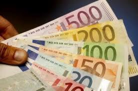 Dłoń trzymająca wachlarz banknotów euro o różnych nominałach: 500, 200, 100, 50, 20 i 10, widoczne szczegóły zabezpieczeń.