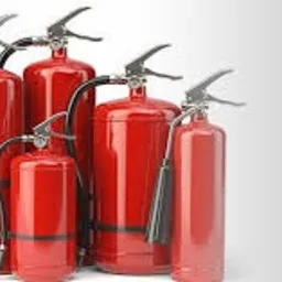 Grupa czerwonych gaśnic o różnych rozmiarach ustawionych na białym tle, widoczne zawleczki zabezpieczające.