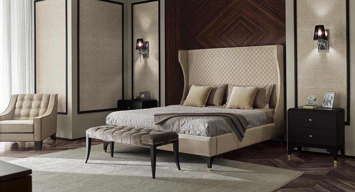 Elegancka sypialnia z łóżkiem tapicerowanym w beżowej tonacji, pikowanym zagłówkiem, oraz aksamitną ławką; w tle panele dekoracyjne na ścianach i lampki nocne z abażurami.