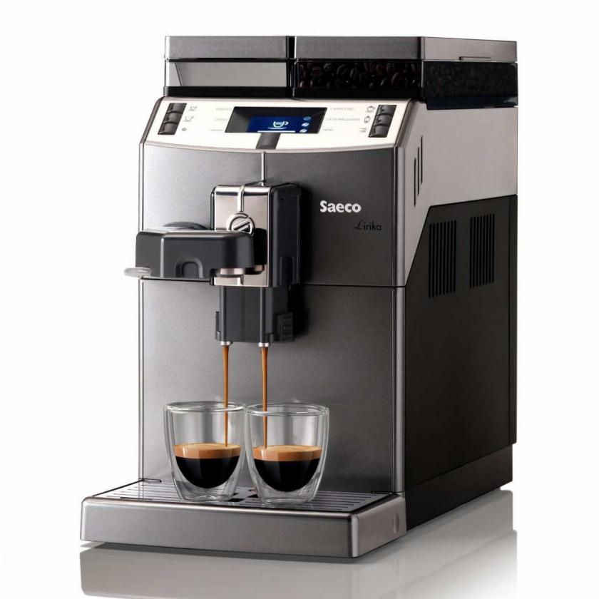 Automatyczny ekspres Saeco Lirika w trakcie parzenia dwóch espresso do szklanych filiżanek z podwójnymi ściankami, widoczny wyświetlacz i zasobnik na ziarna kawy.