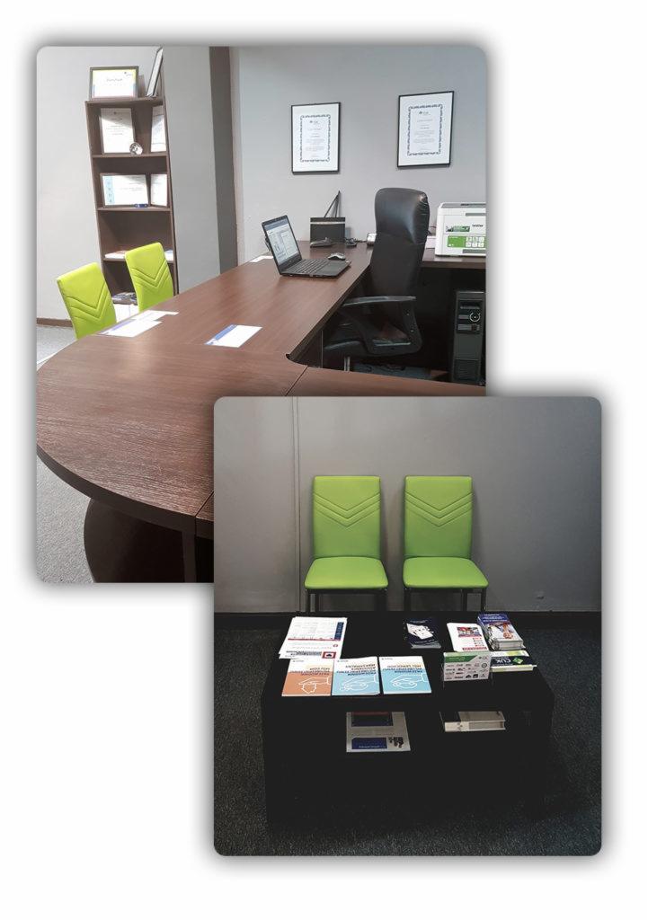 Biuro z dużym drewnianym stołem, zielonymi krzesłami, laptopem i dokumentami w ramkach na ścianie, dodatkowo stolik kawowy z materiałami informacyjnymi.