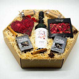 Stylowy kosz upominkowy z bezalkoholowym winem, aromatycznymi herbatami, czekoladą rzemieślniczą i dodatkami korzennymi. Zapakowany w eleganckie pudełko z naturalnym wypełnieniem. Prezent świąteczny lub okolicznościowy dla pracowników, klientów i bliskich.