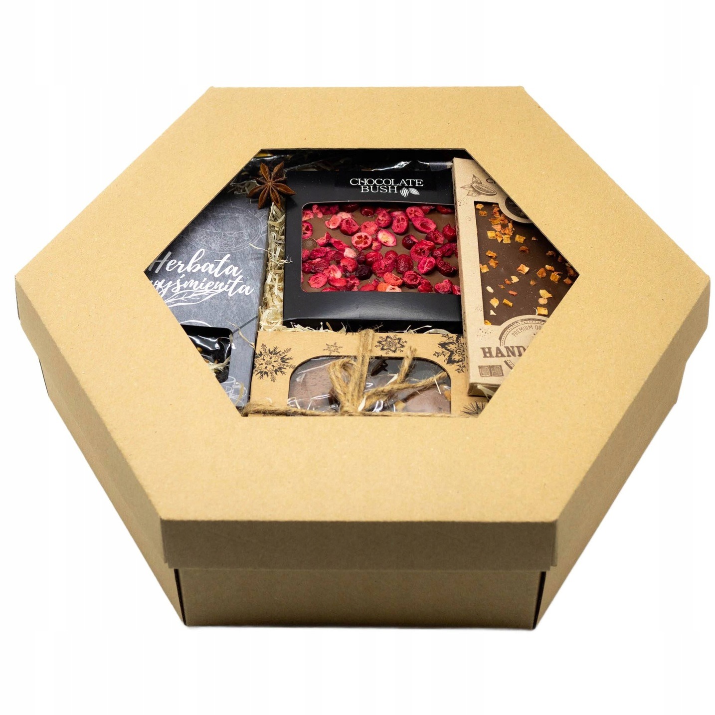 Otwarty, sześciokątny karton z herbatą, czekoladami i anyżem gwiazdkowym. Ręcznie robione słodkości w estetycznym opakowaniu, idealne na prezent.
