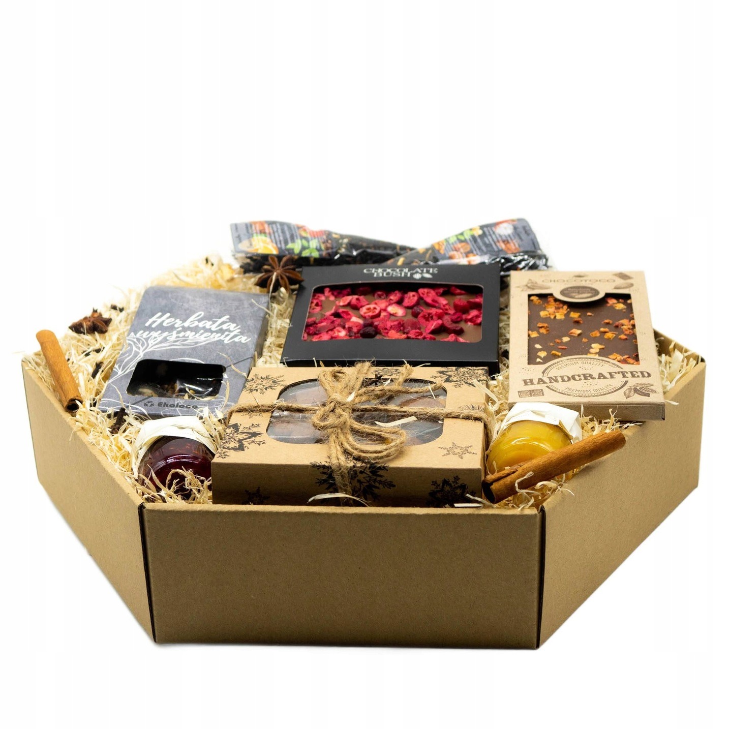 Ręcznie robiony zestaw upominkowy w kartonowym pudełku, wypełniony słodyczami, herbatą i miodem, udekorowany laskami cynamonu i anyżem gwiaździstym.