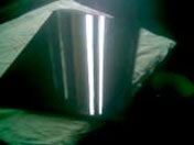 Błyszcząca, lakierowana powierzchnia formatek meblowych odbijająca światło w ciemnym otoczeniu.