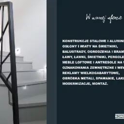 Nowoczesna, minimalistyczna balustrada schodowa z czarnych, ukośnych prętów, zamontowana na jasnych schodach w jasnym wnętrzu. Na ścianie widoczne subtelne oświetlenie.