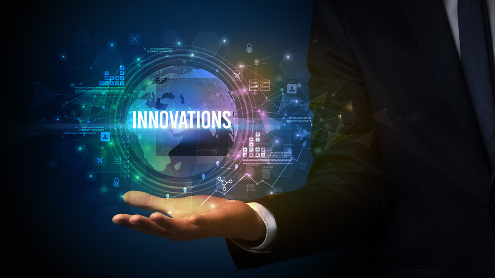 Dłoń mężczyzny w garniturze prezentująca cyfrową wizualizację kuli ziemskiej z napisem 'INNOVATIONS' oraz elementami graficznymi symbolizującymi dane i połączenia sieciowe.