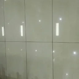 Jasne, błyszczące płytki ceramiczne ułożone na ścianie, widoczne odbicia światła.