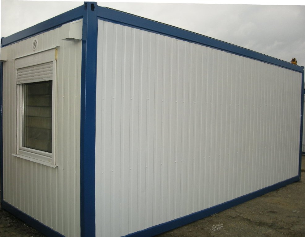 Kontener biurowy z oknem i roletą zewnętrzną, obudowany blachą trapezową w kolorze białym z niebieskimi elementami konstrukcyjnymi.