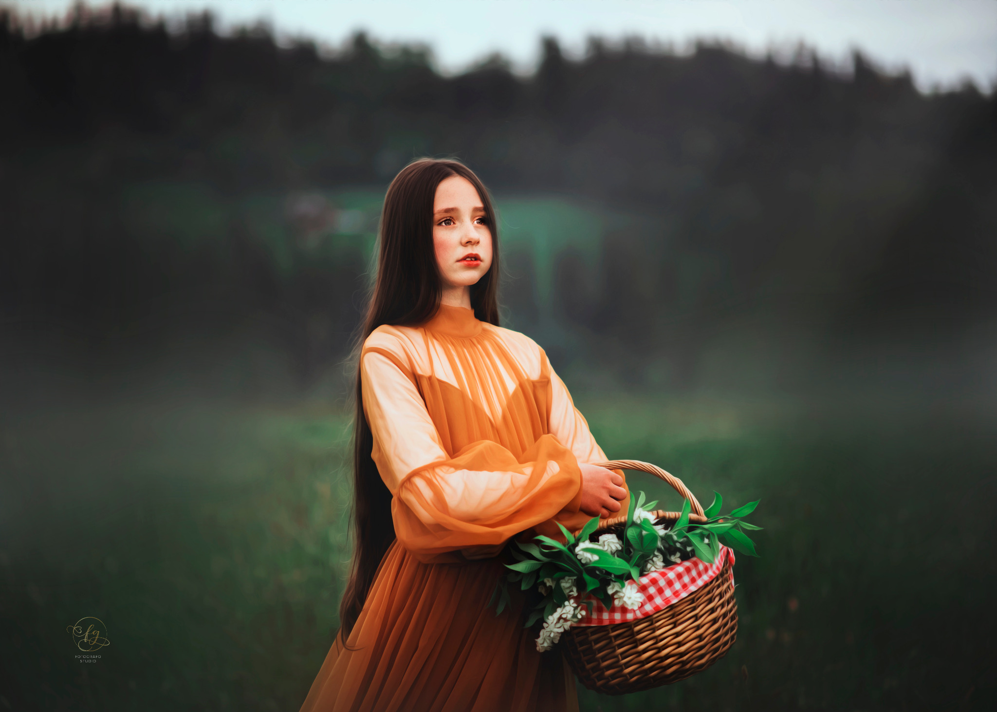 Portret dziewczynki w pomarańczowej sukience z koszem białych kwiatów na tle zielonego krajobrazu. Dziewczynka ma długie, ciemne włosy i zamyślony wyraz twarzy.