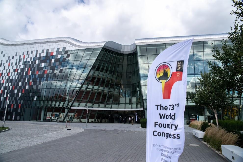 Nowoczesne centrum kongresowe z flagą informującą o 73. Światowym Kongresie Odlewnictwa w Krakowie, Polska.