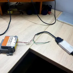 Diagnostyka modułu sterującego Audi Bosch w Ełku, podłączonego do interfejsu diagnostycznego na drewnianym biurku.