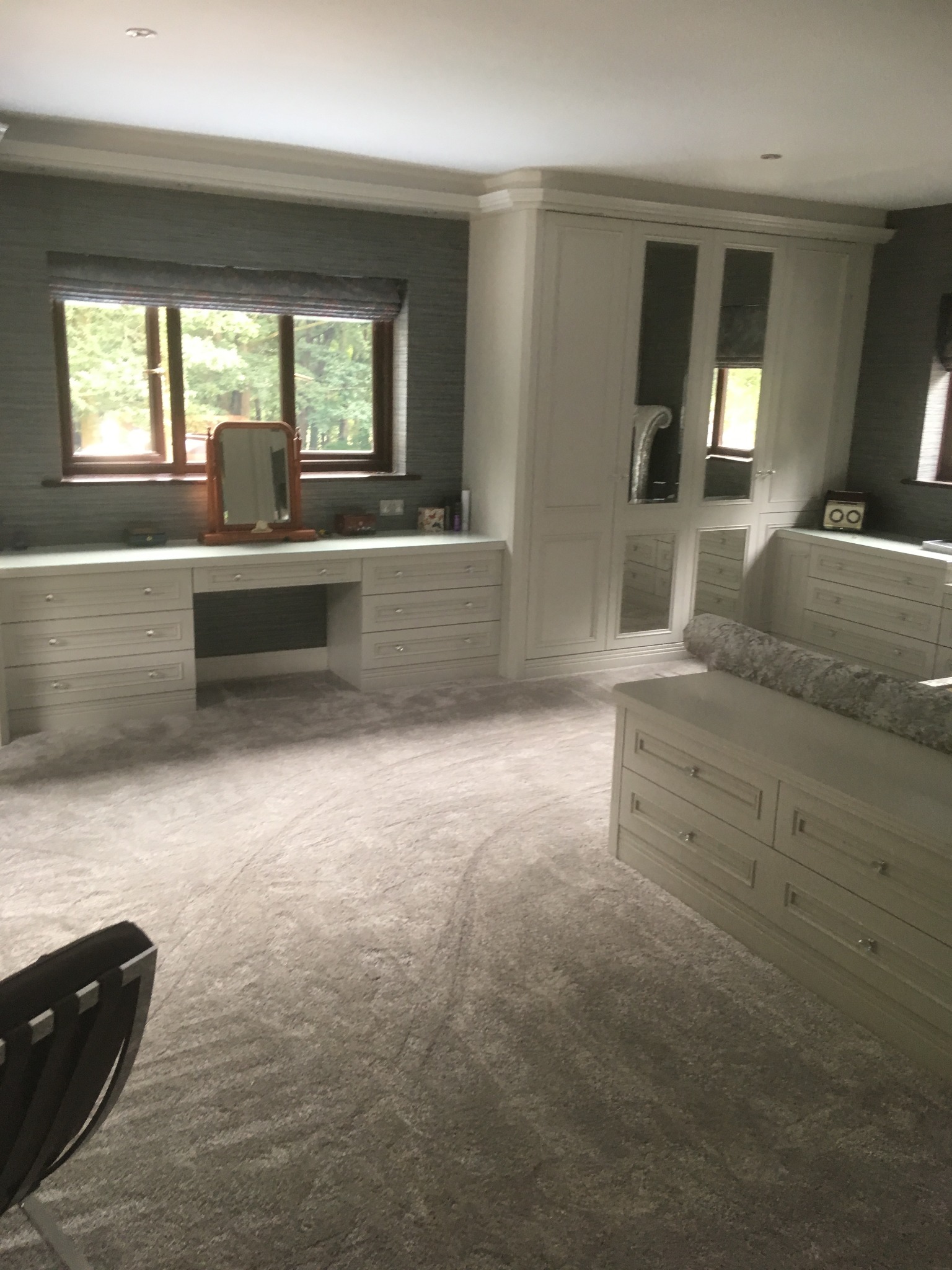 Jasna, przestronna garderoba z szafą wnękową z lustrzanymi drzwiami, toaletką z lustrem i szufladami w Ołdrzychowicach Kłodzkich.