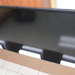 Nowy telewizor LED w kartonowym opakowaniu z piankowym wypełnieniem, gotowy do montażu lub transportu.