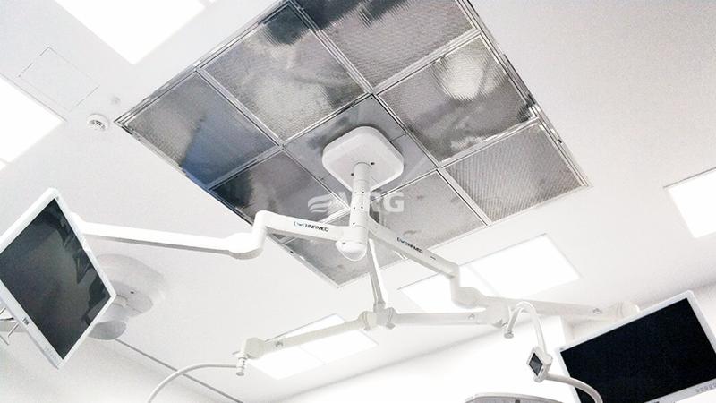 Sufit w sali operacyjnej z widocznym systemem laminarnym nawiewu powietrza, oświetleniem operacyjnym i monitorami medycznymi.