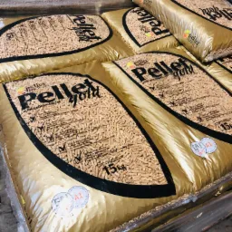 Stos worków z certyfikowanym pelletem drzewnym, ułożonych na palecie i owiniętych folią, widoczne oznaczenia normy ENplus A1 na opakowaniach.