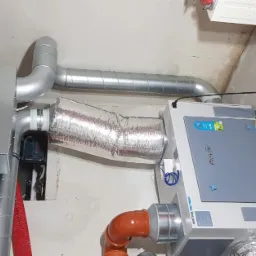 Instalacja rekuperacji Pro-Vent Mistral PRO 700EC z izolowanymi przewodami wentylacyjnymi, widoczne elementy montażowe na surowej ścianie i skrzynka narzędziowa Milwaukee.