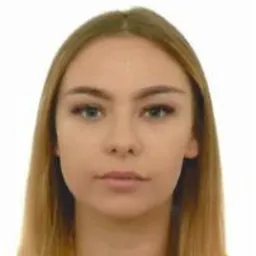 Portret młodej kobiety z długimi blond włosami i niebieskimi oczami na białym tle. Neutralny wyraz twarzy, profesjonalny makijaż.