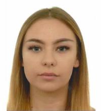 Portret młodej kobiety z długimi blond włosami i niebieskimi oczami na białym tle. Neutralny wyraz twarzy, profesjonalny makijaż.