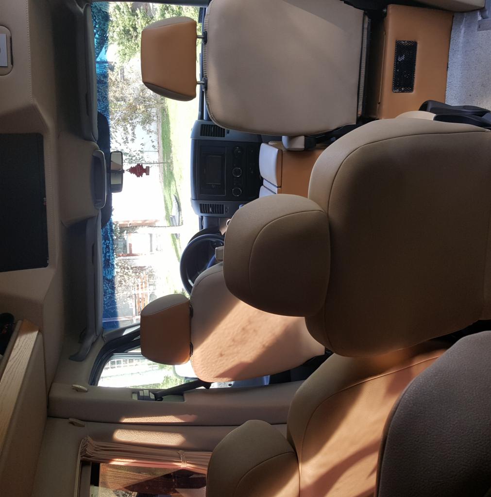 Wnętrze przestronnego busa z jasną tapicerką widziane z perspektywy pasażera w Jakubowicach Konińskich, z widocznym kokpitem kierowcy i fotelami pasażerskimi.