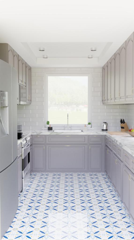 Wąska kuchnia w odcieniach szarości z wzorzystą biało-niebieską podłogą, widok na okno z zielenią na zewnątrz.