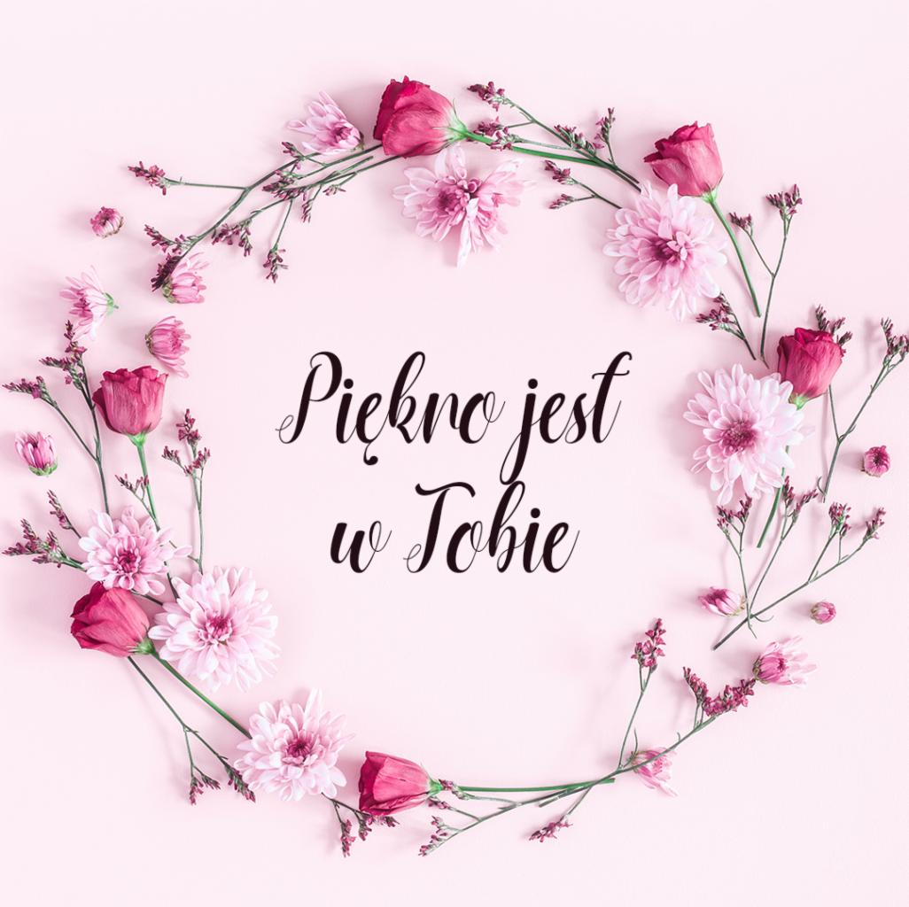 Różowo-biały wieniec z kwiatów i gałązek otaczający napis 'Piękno jest w Tobie' na jasnoróżowym tle.