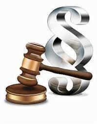 Drewniany młotek sędziowski z brązowymi akcentami i duży, srebrny paragraf na białym tle.