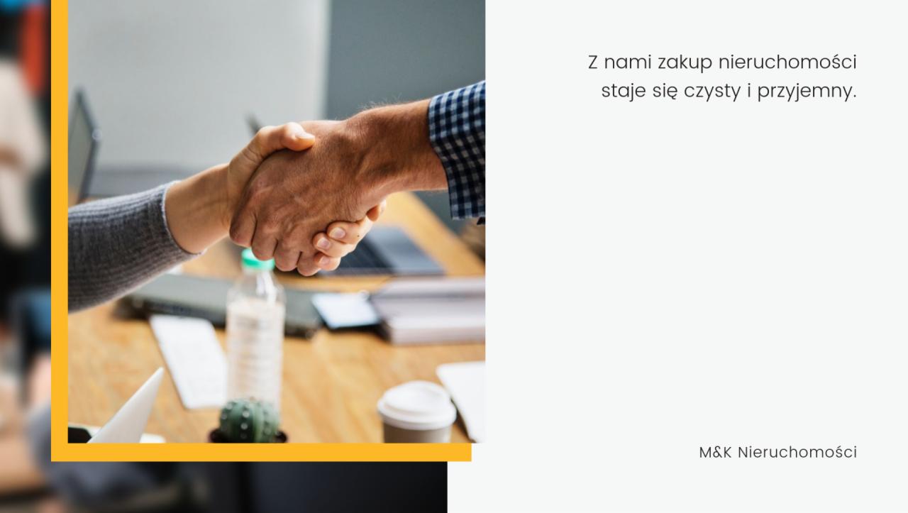 Uścisk dłoni nad biurkiem z laptopem, butelką wody i kaktusem, symbolizujący udane porozumienie w branży nieruchomości.