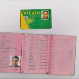 Francuski dowód osobisty i karta ubezpieczenia zdrowotnego Vitale leżące obok siebie. Widoczne dane personalne i zdjęcie.