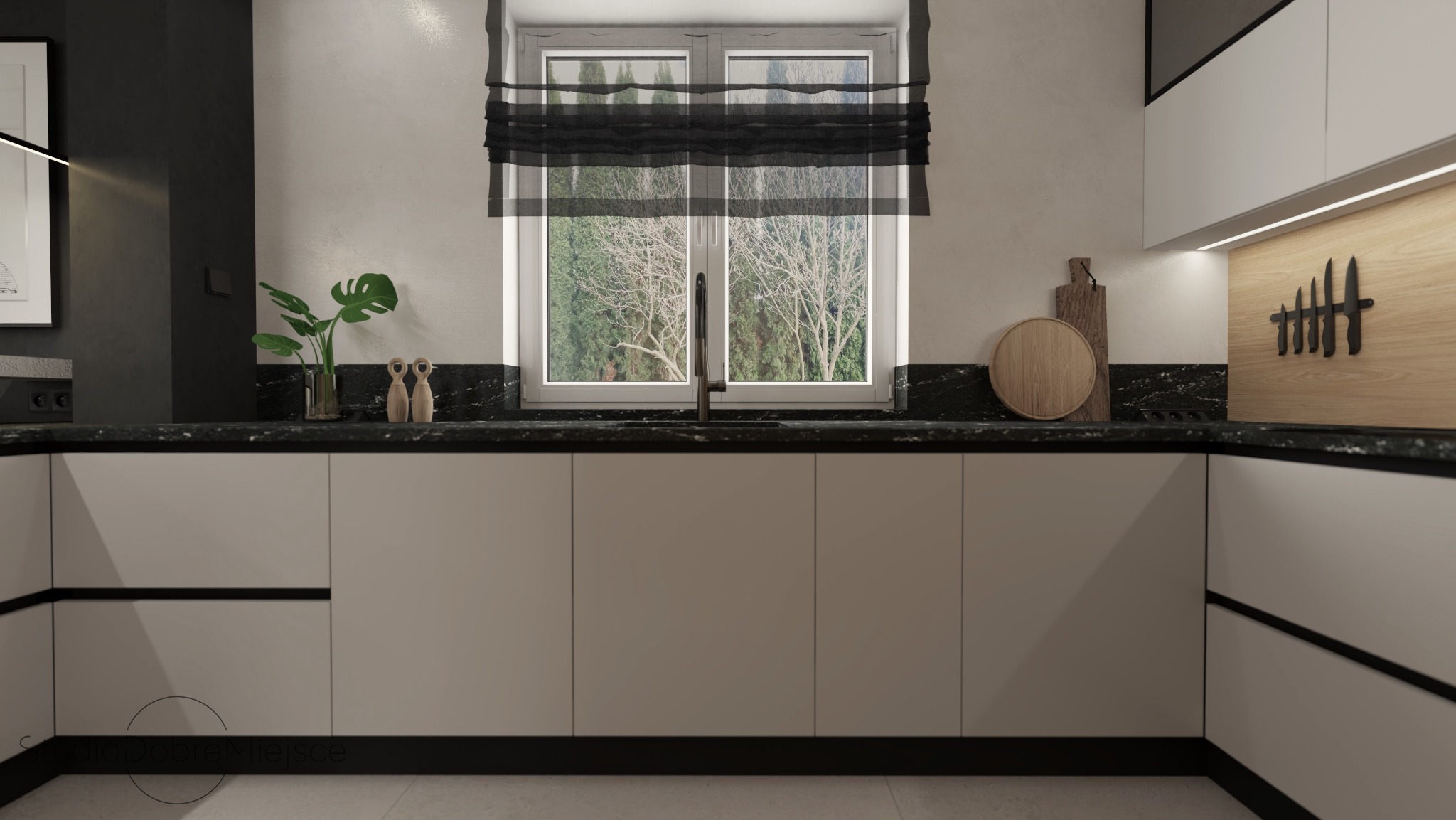 Minimalistyczna kuchnia z ciemnym blatem i oknem z roletą rzymską. Na blacie dekoracje: roślina w szklanym wazonie i drewniane figurki. Drewniane deski do krojenia.