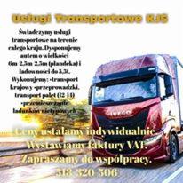 Czerwony samochód ciężarowy marki Iveco z tekstem reklamowym usług transportowych, widoczny numer telefonu kontaktowego i informacja o wystawianiu faktur VAT, na tle rozmytego krajobrazu.