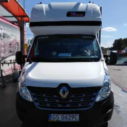 Biały Renault Master z nadbudową, zaparkowany przed myjnią samochodową, widoczne tablice rejestracyjne GS 0629C.