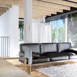 Moduu Magdalena Rosowska - Jasne wnętrze z drewnianym sufitem i parkietem w jodełkę. Czarna skórzana sofa na tle okien z widokiem na zieleń. Minimalistyczny design, naturalne światło.
