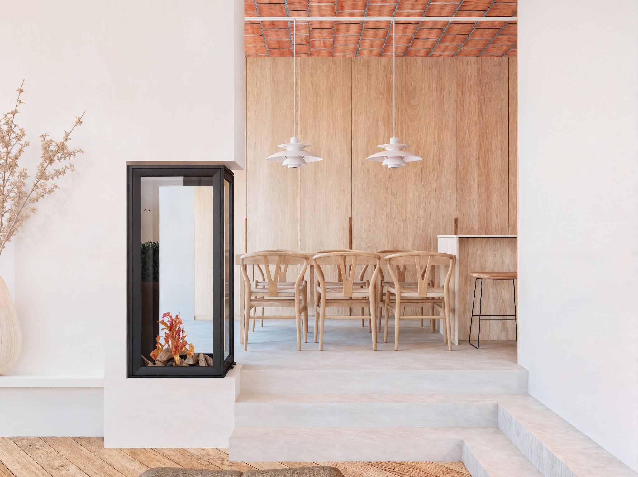 Jasne, minimalistyczne wnętrze z kominkiem, drewnianą ścianą i designerskimi lampami. Widok na jadalnię z drewnianymi krzesłami i schodami.