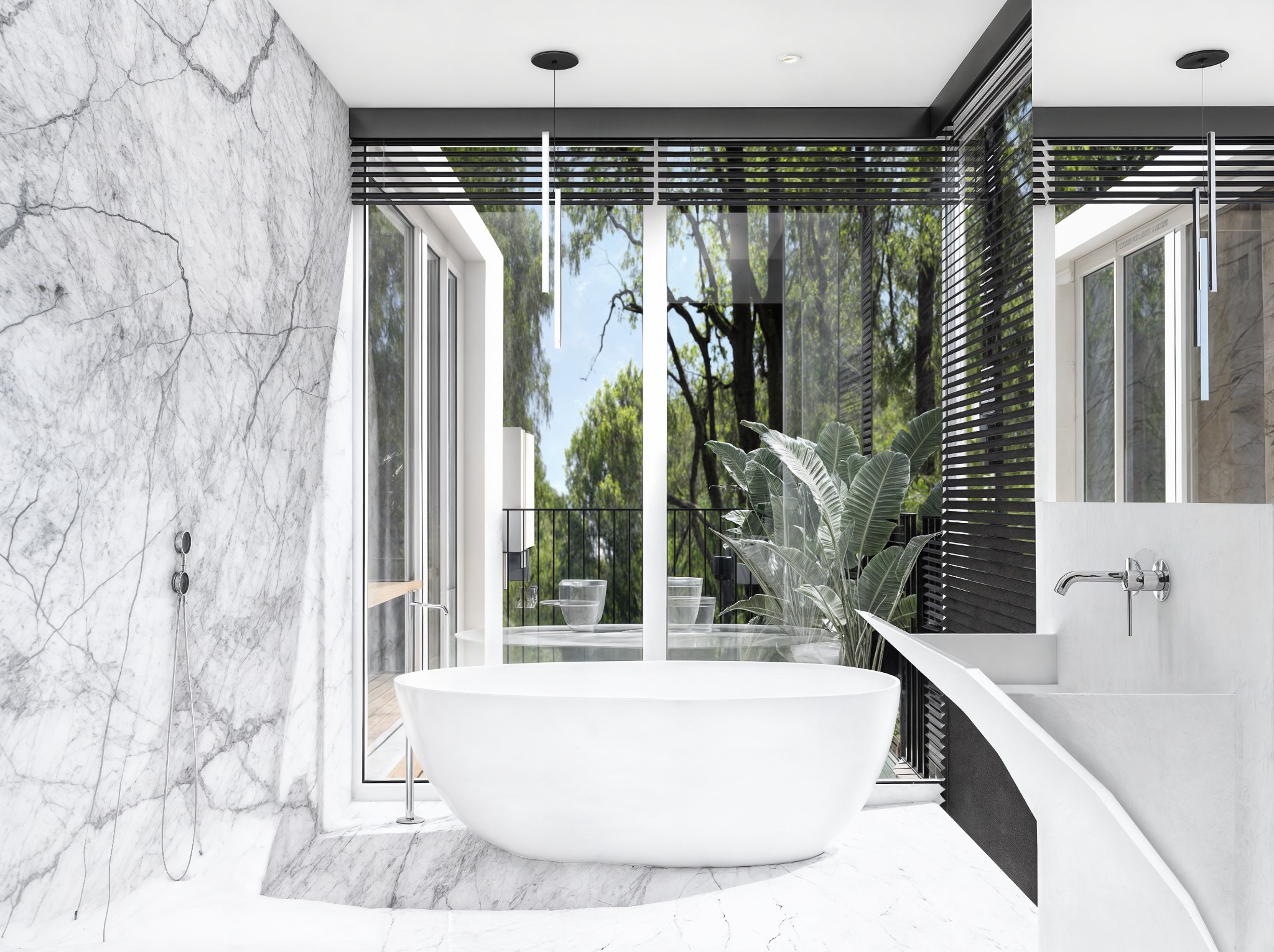 Nowoczesna, marmurowa łazienka z wolnostojącą wanną na tle okna z widokiem na zieleń. Minimalistyczna armatura i oświetlenie podkreślają elegancję wnętrza.