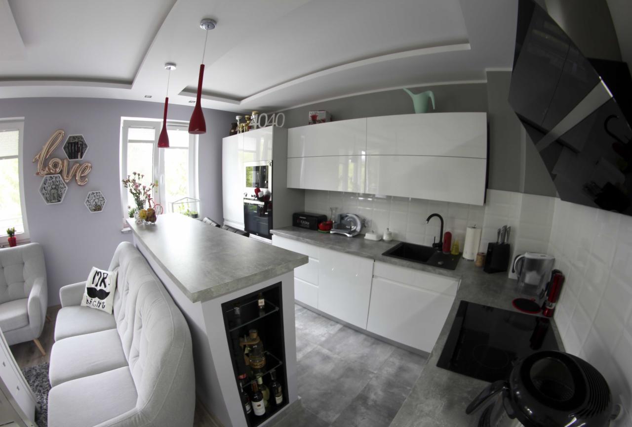 Nowoczesna kuchnia z białymi szafkami, szarym blatem i wyspą z barkiem, widok z perspektywy rybiego oka.