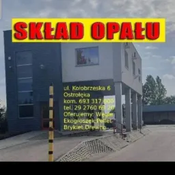 Budynek składu opału z żółtym szyldem i napisem 'SKŁAD OPAŁU', adres i numery telefonów widoczne na elewacji.