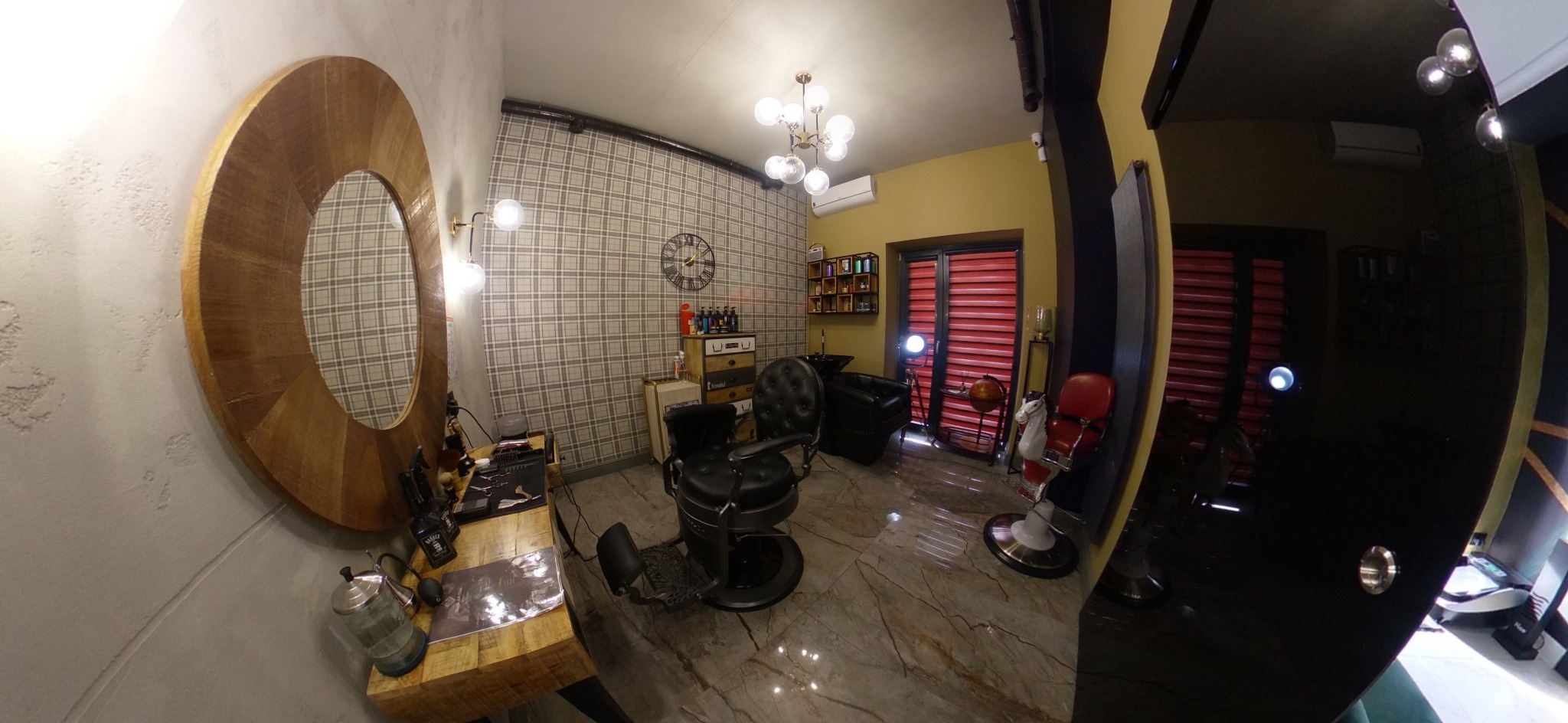 Wnętrze salonu barberskiego z dwoma fotelami, drewnianym lustrem w kształcie elipsy i ścianą w kratę.