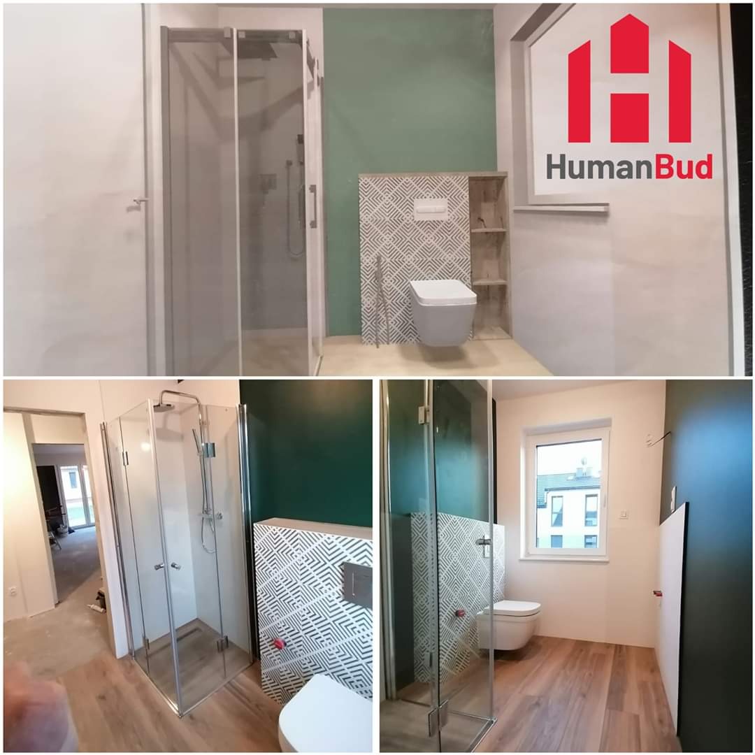 Wnętrze łazienki w trakcie wykańczania, z kabiną prysznicową ze szklanymi drzwiami, toaletą podwieszaną z płytkami dekoracyjnymi, ścianą pomalowaną na zielono i logiem firmy HumanBud w prawym...