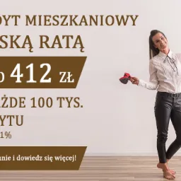 Kobieta w białej koszuli i czarnych spodniach, trzymająca czerwone szpilki, na tle grafiki z informacją o niskiej racie kredytu mieszkaniowego i logo firmy finansowej.