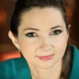 Portret kobiety z delikatnym uśmiechem, brązowymi oczami i zielonym cieniem na powiekach, ubrana w turkusową bluzkę.