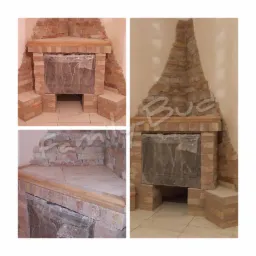 Fragment narożnego kominka obłożonego okładziną z kamienia naturalnego w odcieniach beżu i brązu, zabezpieczonego folią ochronną, z drewnianym blatem i elementami wykończeniowymi, na tle jasnej...