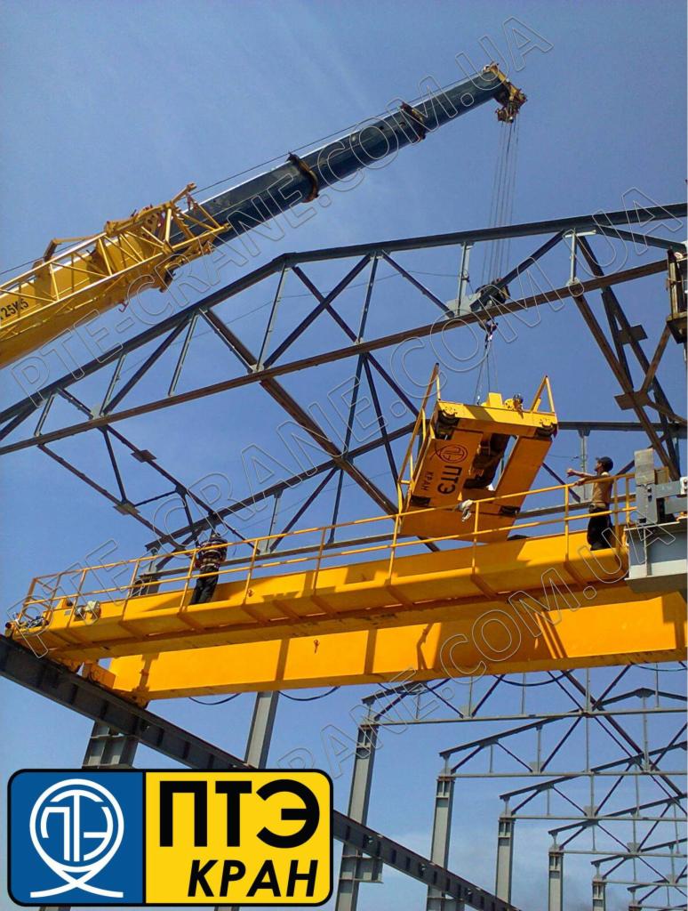 Żółty dźwig budowlany podnosi element konstrukcji stalowej, dwóch pracowników na platformie, błękitne niebo w tle, widoczne logo firmy na dole zdjęcia.