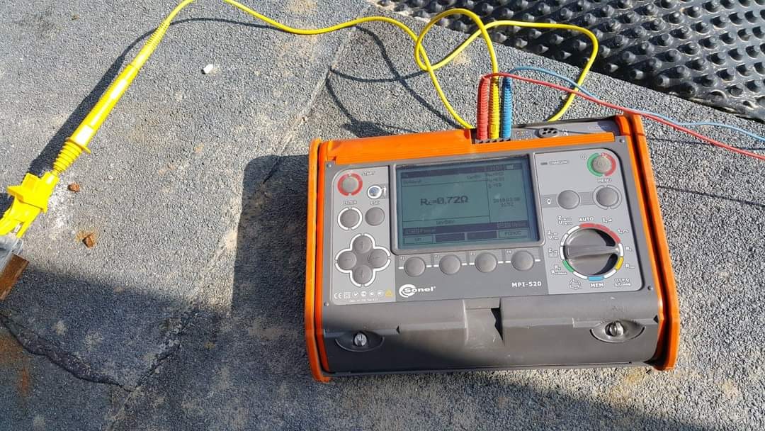 Miernik Sonel MPI-520 z podłączonymi przewodami pomiarowymi, wskazujący wartość rezystancji 0.72Ω, leżący na szarej, teksturowanej powierzchni.